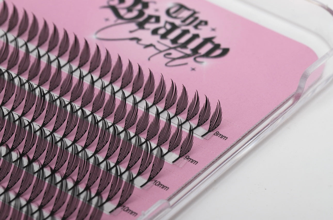 False eyelashes in a clear case with a pink background and 'The Beauty' branding.